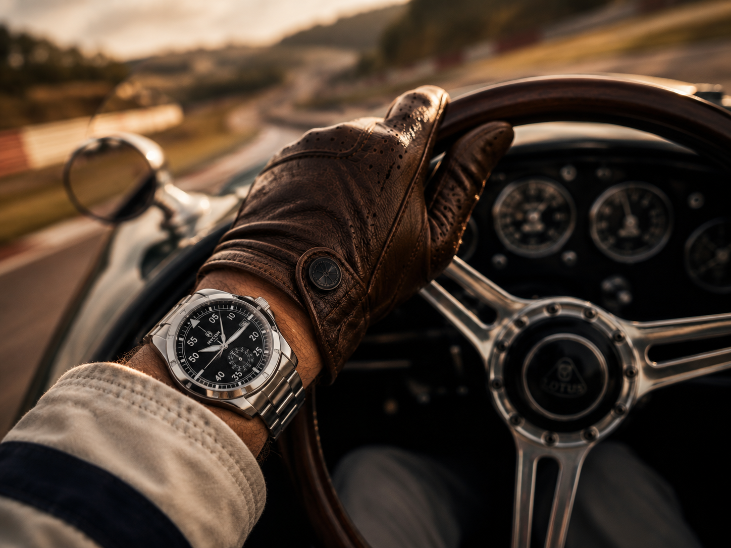 HYCON chronograph on a driver's wrist against a classic car steering wheel